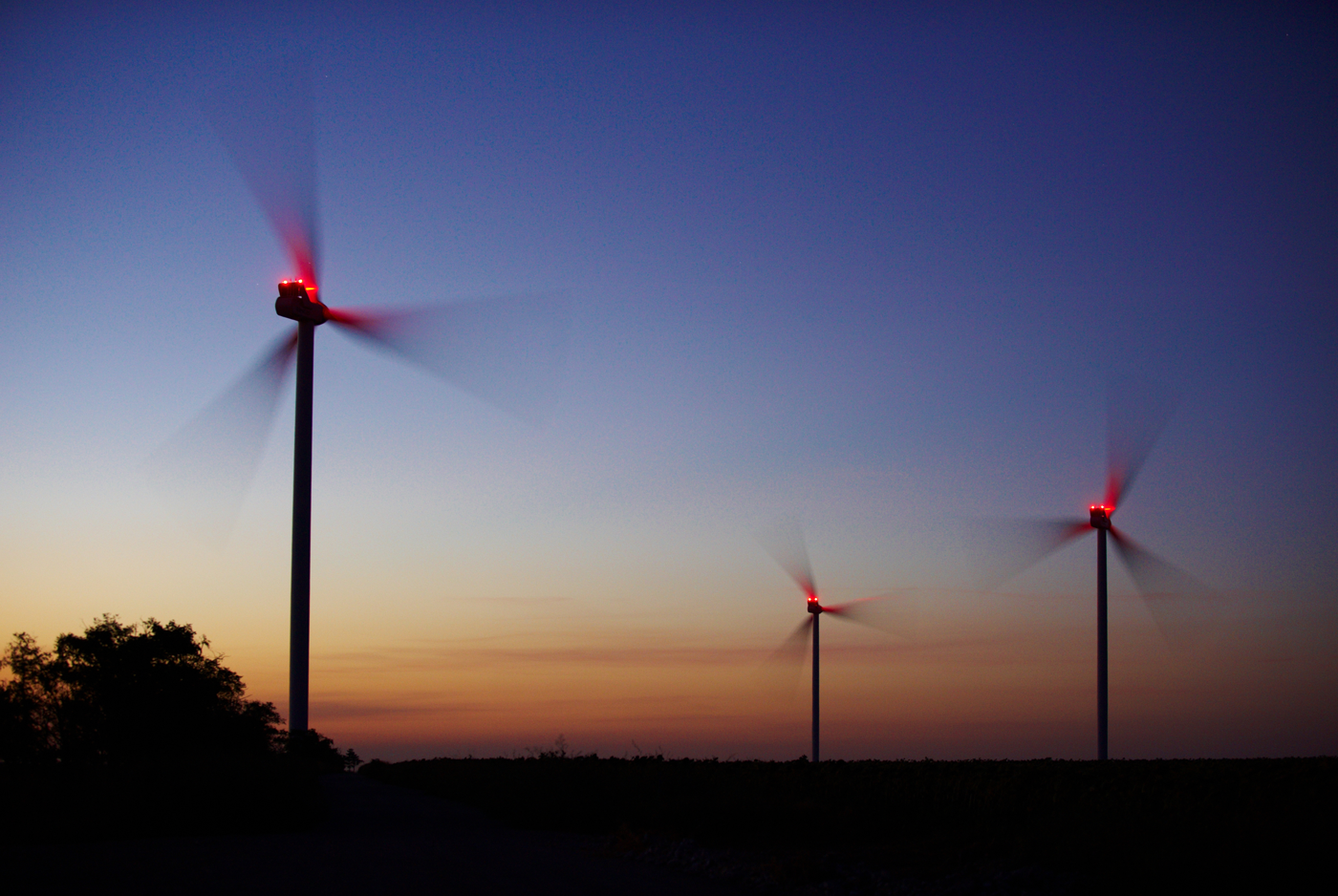 Drei Windenergieanlagen bei Nacht mit Beleuchtung, Foto: © sunsand-stock.adobe.com